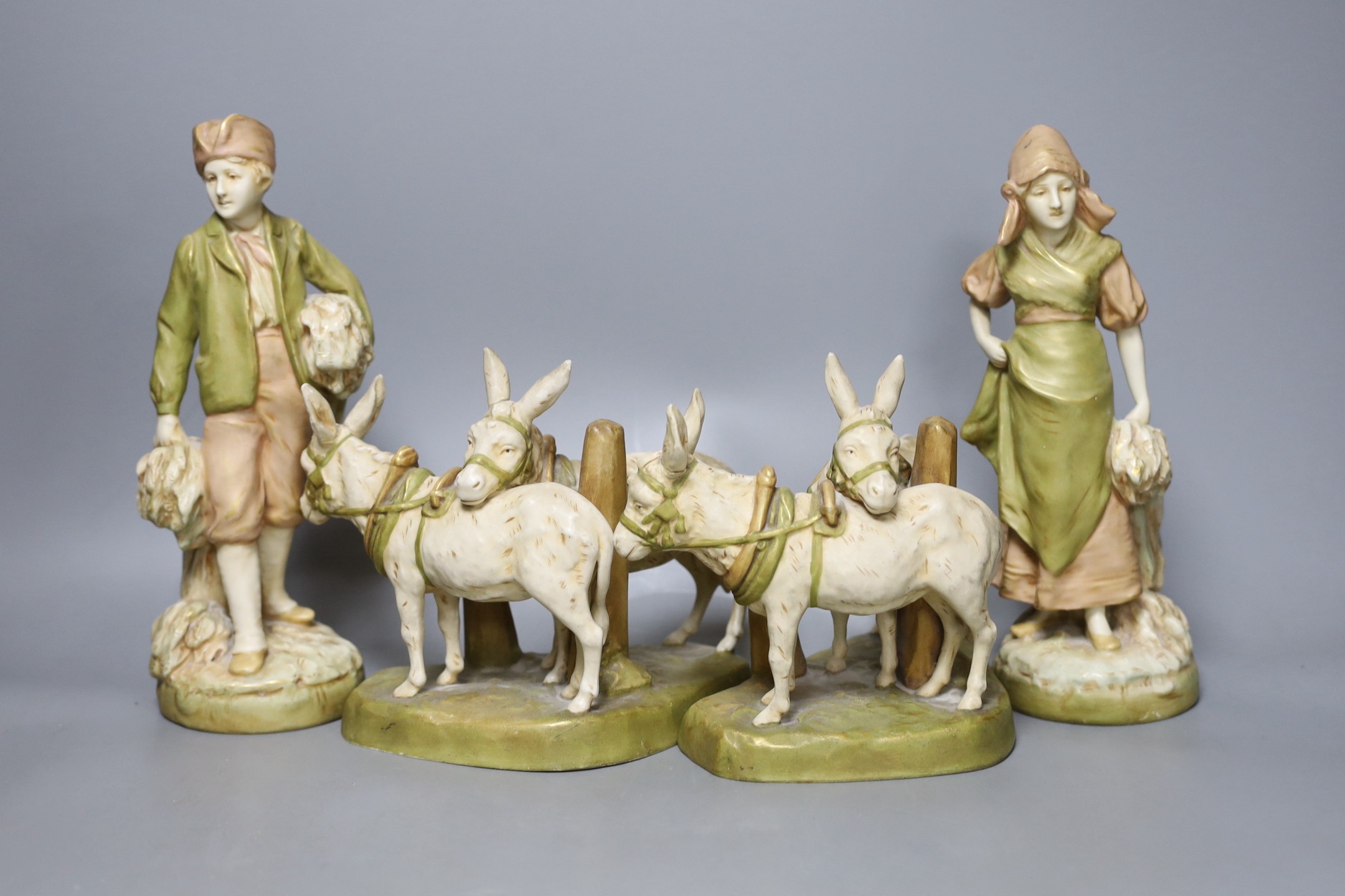 A pair of Royal Dux figures and a pair of Royal Dux donkey groups, 24cm